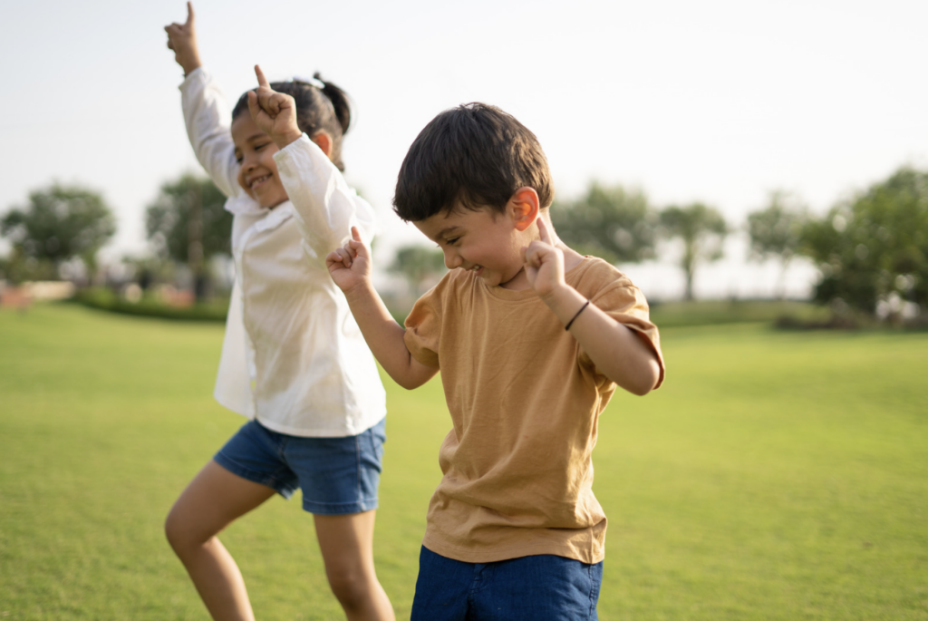 This is an image of a little girl and boy laughing